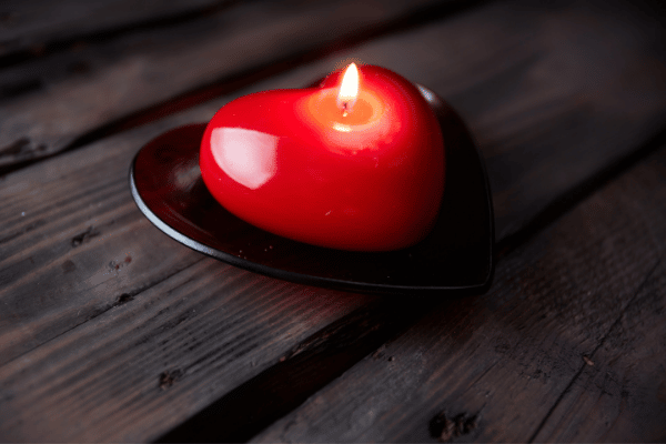 heart candle with lit flame