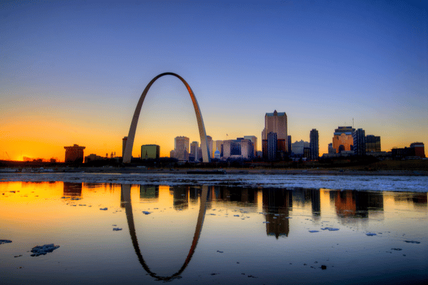 Sunset over the St. Louis Arch and skyline with water reflection