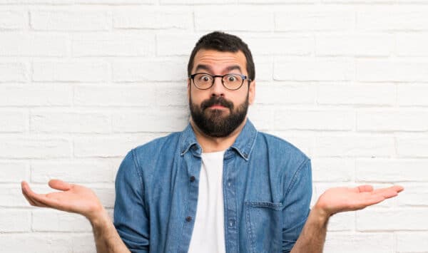 Man with hands in the air looking exasperated, going through divorce can be difficult