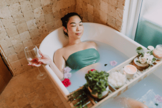 Woman Relaxing In A Bath With A Glass Of Wine